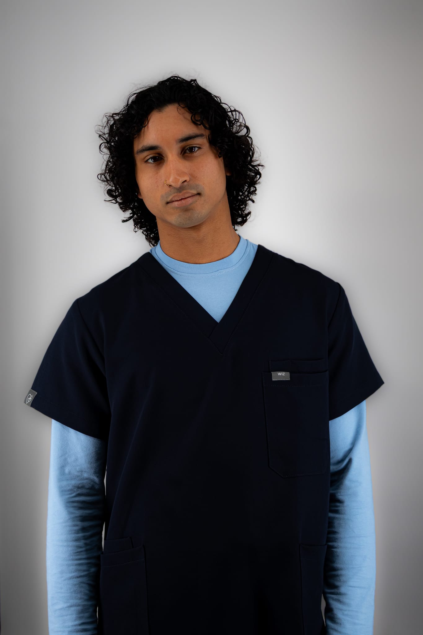Man in navy WiZscrubs over a sky blue underscrub