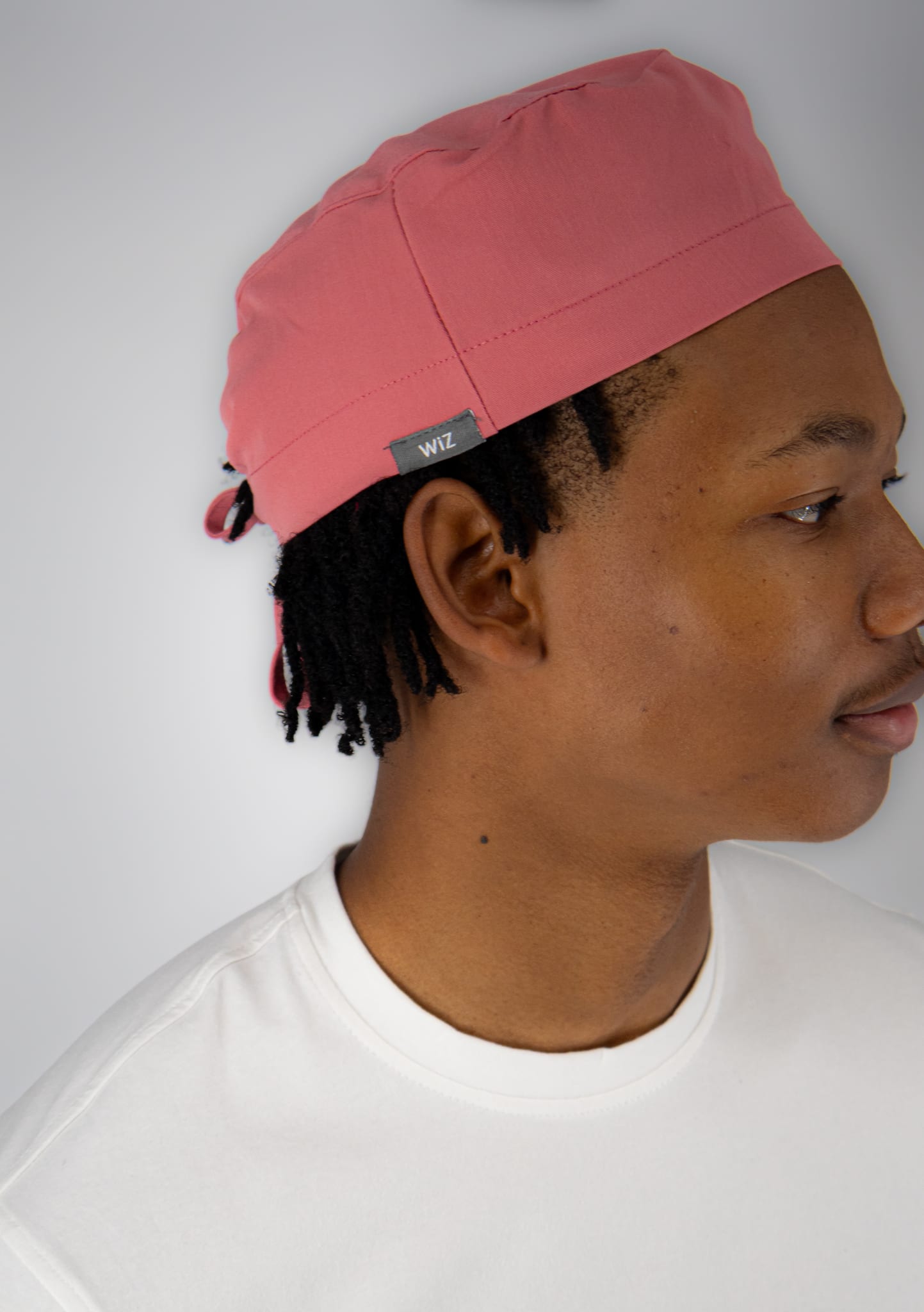 Student in a coral WiZ Scrub Cap Pro