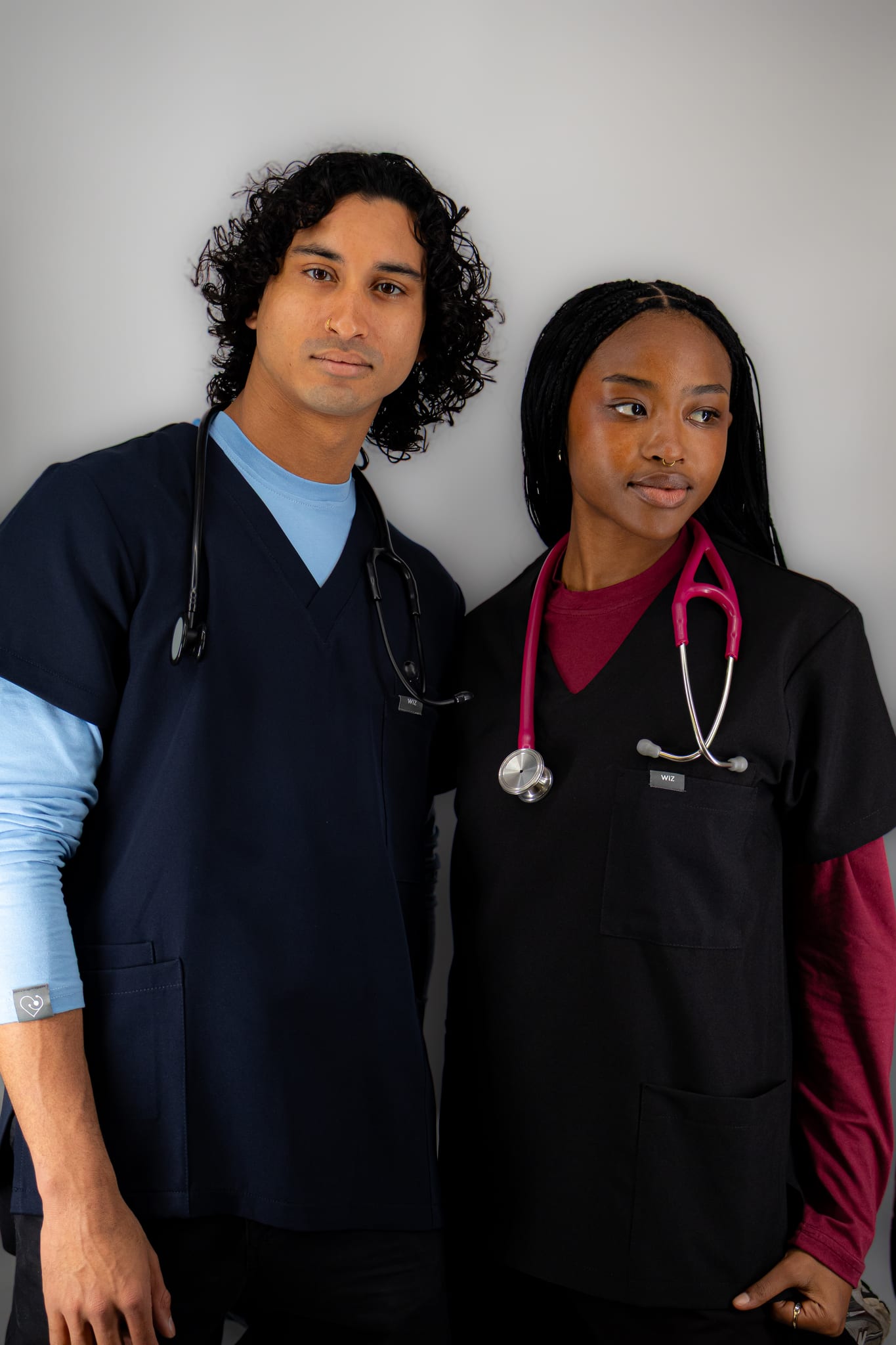 Two medical students in WiZ Scrubs with stethoscopes, standing side by side