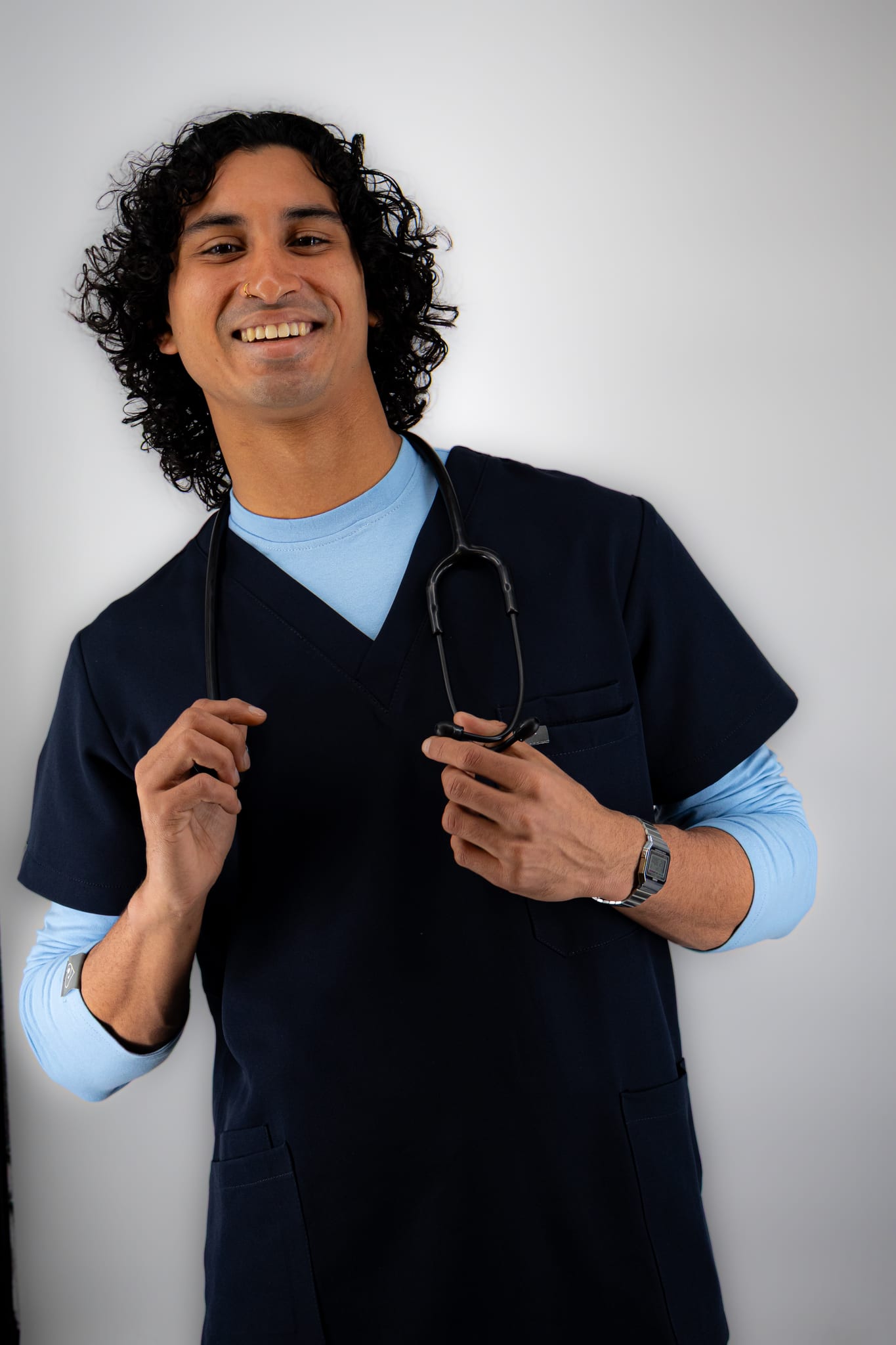 Student in navy WiZscrubs with a sky blue long-sleeve underscrub