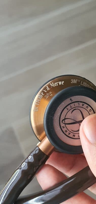 Copper Littmann chestpiece with a name engraved in script, held in a hand