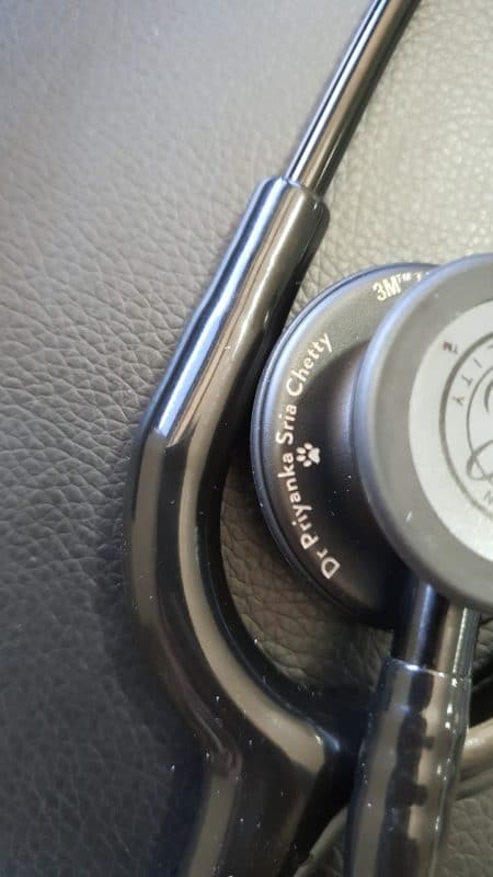 Smoke-finish Littmann chestpiece engraved with a doctor's name in script and a paw print icon